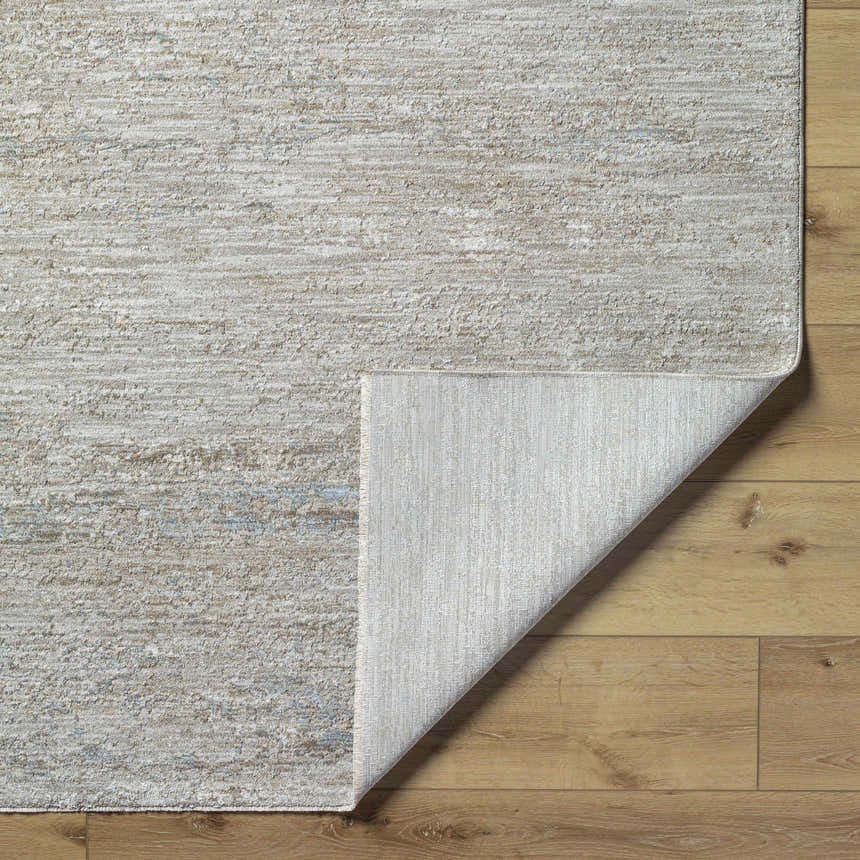 Close-up of the light gray and natural gray Levon Area Rug showing texture and backing on wood floor. Fold