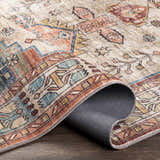 Close-up of the Snell Area Rug showing its traditional oriental pattern in amber, brick red, and blue hues. Microfiber texture. Fold