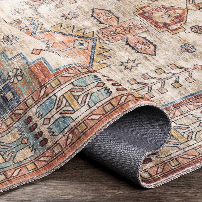 Close-up of the Snell Area Rug showing its traditional oriental pattern in amber, brick red, and blue hues. Microfiber texture. Fold