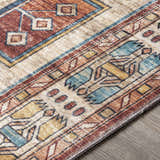 Close-up of the Snell Area Rug showing its traditional Southwestern pattern in amber, brick red, and denim blue hues. Texture