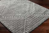 Close up of the gray Edsel Area Rug showing shag texture and geometric pattern on dark wood flooring. Corner