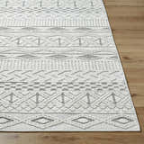 Close-up of the Sokka Area Rug showing its cream and light gray geometric pattern and textured, machine-woven construction. Front