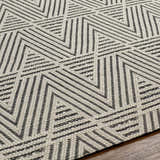 Close up of the Dawid Wool Area Rug featuring a black and bone geometric pattern. Texture