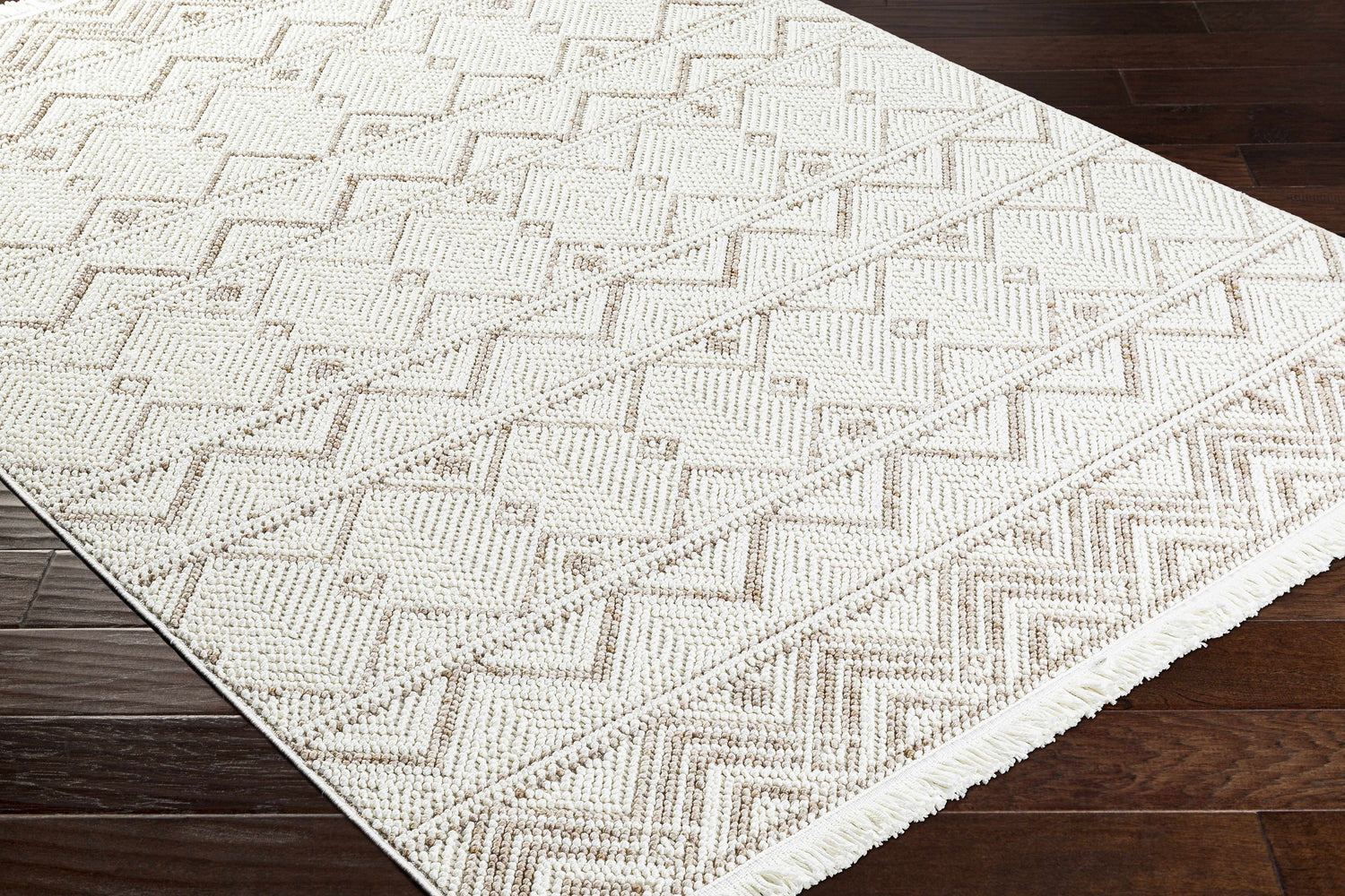Close-up of the Armen Area Rug showing its beige, cream, and gray geometric pattern and textured weave. Corner