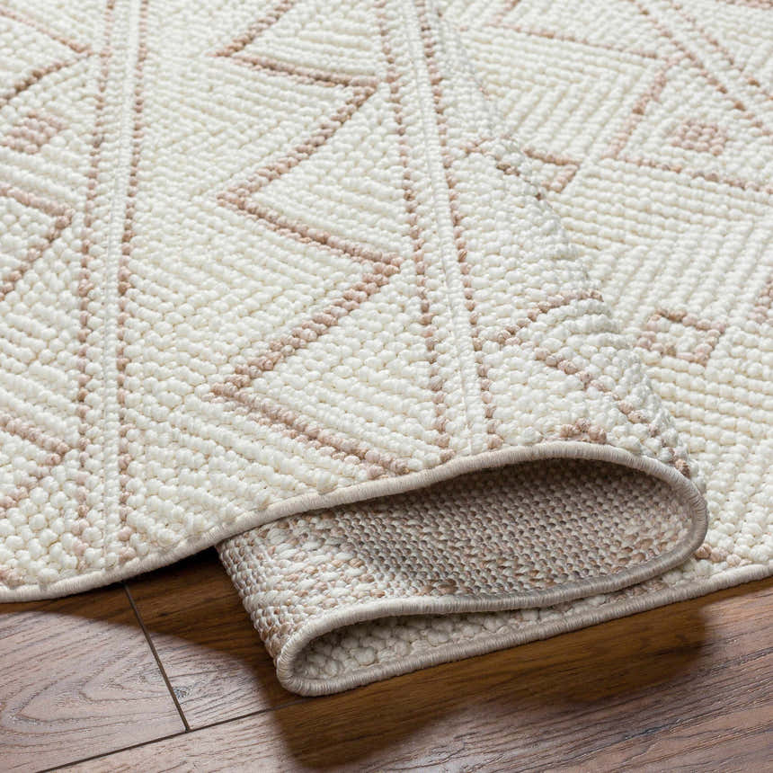 Close-up of the Armen Area Rug showing a geometric pattern in cream and beige on a textured, machine-woven surface. Fold