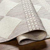 Close-up of the Igone Area Rug showing its beige, gray, and brown geometric pattern and textured, machine-woven construction. Fold