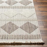 Close up of the Igone Area Rug showing beige and brown diamond pattern and fringe detail on wood floor. Front