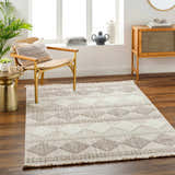 Living room scene with a beige Igone Area Rug, woven chair, wood cabinet, and neutral decor. Farmhouse style. Roomscene-Rectangle