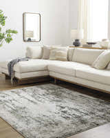 Living room with a light gray Omari Area Rug, cream sectional sofa, wood floors, and neutral decor. Roomscene-Rectangle