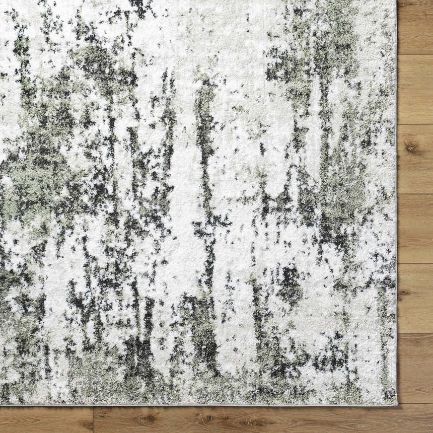 Close-up of the light gray Omari Area Rug showing its contemporary abstract pattern and soft texture on a wood floor. Corner