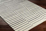 Close up of the Gawel Charcoal Area Rug showing its beige and charcoal striped pattern and hand-tufted texture. Corner