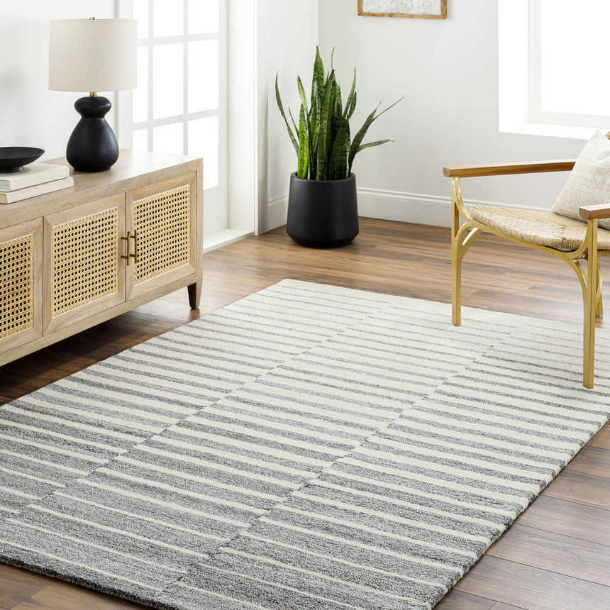 Living room scene with a Gawel Gray Area Rug, wood floors, console table, lamp, plant, and gold chair. Roomscene-Rectangle
