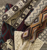Close-up of rolled Pawhuska Area Rugs. Wool rugs in charcoal, peach, and traditional farmhouse patterns. Styleshot