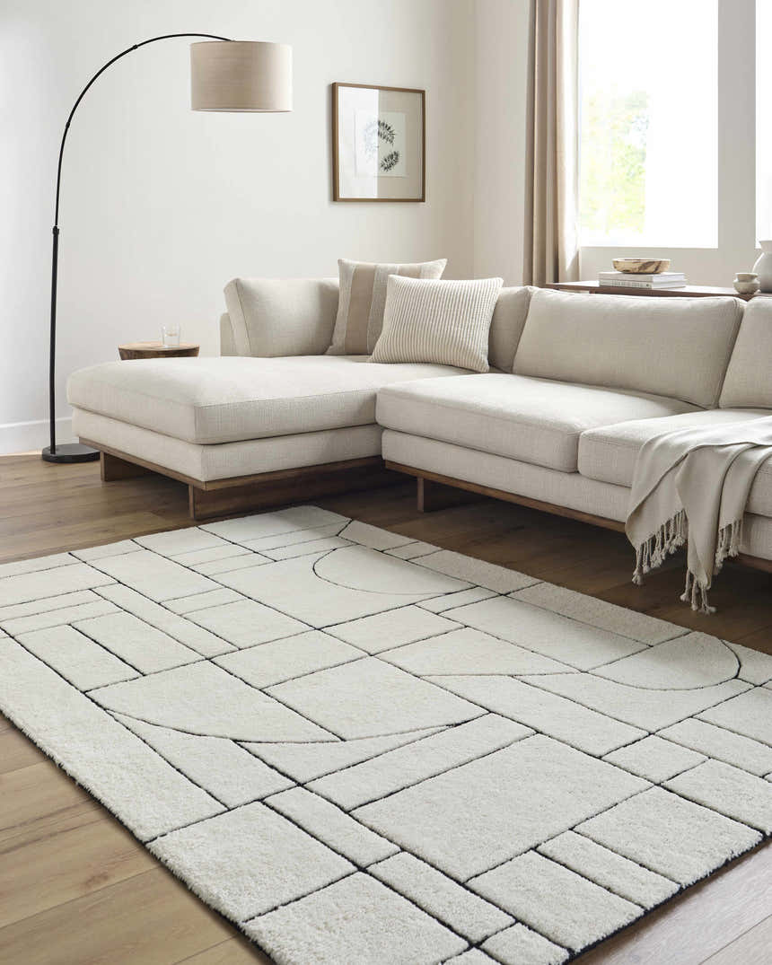 Living room with a beige sectional and Fusao Rose Cream Area Rug featuring a geometric pattern. Roomscene-Rectangle
