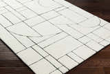 Close-up of Fusao Rose Cream Area Rug. Beige wool rug with a contemporary geometric pattern and hand-tufted texture. Corner