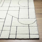Close up of the Fusao Rose Cream Area Rug showing its beige wool texture and black geometric line pattern. Front
