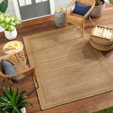 Outdoor patio scene with the beige Freja Flatweave Faux Jute Rug, wicker chairs, plants, and wood deck. Roomscene-Rectangle
