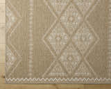 Close-up of the Olina Flatweave Faux Jute Rug. Khaki and tan rug with a diamond pattern and a flatweave texture. Corner