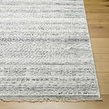 Close-up of the Gray Eldad Area Rug showing its hand-knotted texture, fringe, and Scandinavian-inspired black and white pattern. Front
