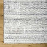 Close-up of the Gray Eldad Area Rug showing its hand-knotted texture, geometric pattern, and black, white, and silver colors. Swatch