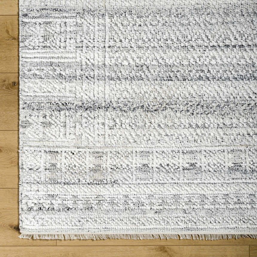 Close-up of the Gray Eldad Area Rug showing its hand-knotted texture, geometric pattern, and black, white, and silver colors. Swatch