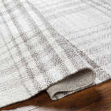 Close-up of the hand-woven Inara Plaid Area Rug, a gray and light gray farmhouse style rug made of recycled PET yarn. Fold