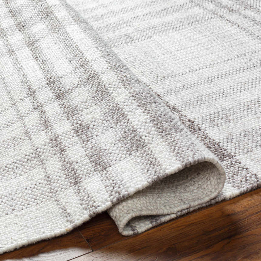 Close-up of the hand-woven Inara Plaid Area Rug, a gray and light gray farmhouse style rug made of recycled PET yarn. Fold