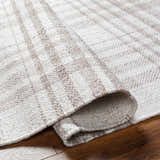 Close-up of the Inara Light Brown Plaid Hand Woven Area Rug showing its beige and brown plaid pattern and hand woven texture. Fold