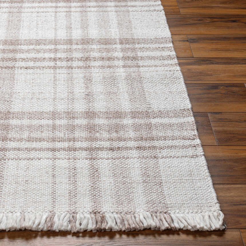 Close-up of the hand woven Inara Light Brown Plaid Area Rug with fringe on dark wood floors. Farmhouse style. Front