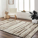 Living room scene with a Maho Ivory Area Rug, woven chair, and wood side table. Roomscene-Rectangle