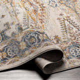 Close-up of the Espy Area Rug showing its traditional oriental pattern and colors: brick red, burnt orange, cream, and dark blue. Fold