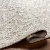 Close up of the hand-tufted White Derya Area Rug showing its farmhouse style pattern and recycled PET yarn texture. Fold