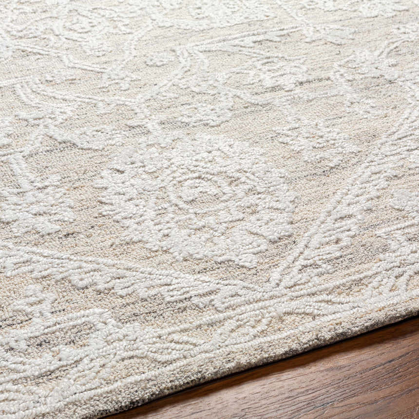 Close-up of the hand-tufted White Derya Area Rug. Farmhouse style with a traditional floral pattern in gray and white tones. Texture