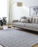 Living room scene with a gray sofa and the Sanvi Gray Area Rug featuring a geometric pattern. Roomscene-Rectangle