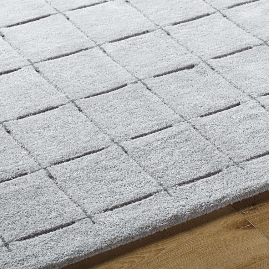Close-up of the Sanvi Gray Area Rug showing its charcoal grid pattern and soft, hand-tufted wool texture. Texture
