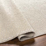 Close-up of the hand-woven Edith Premium Rug in beige and gray, showing the textured, looped pile construction. Fold