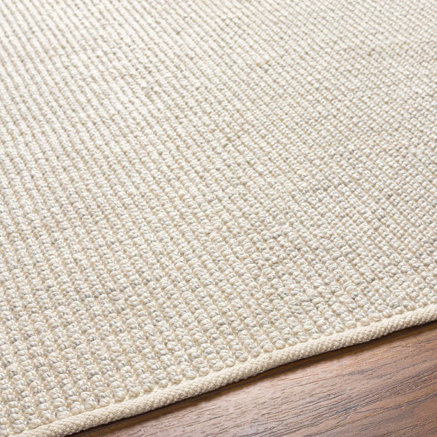 Close up of the hand woven Edith Premium Rug in beige and gray, showing texture. Texture