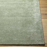 Close-up of the sage Helio Area Rug showing its subtle horizontal texture and soft viscose fibers on hardwood floor. Front