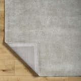 Close up of the hand-tufted Makya Area Rug in metallic silver. Viscose rug with subtle horizontal texture. Fold