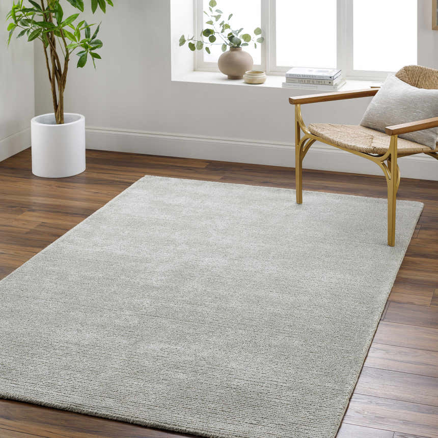 Living room scene with a silver Makya Area Rug, wood floors, chair, and natural light. Roomscene-Rectangle