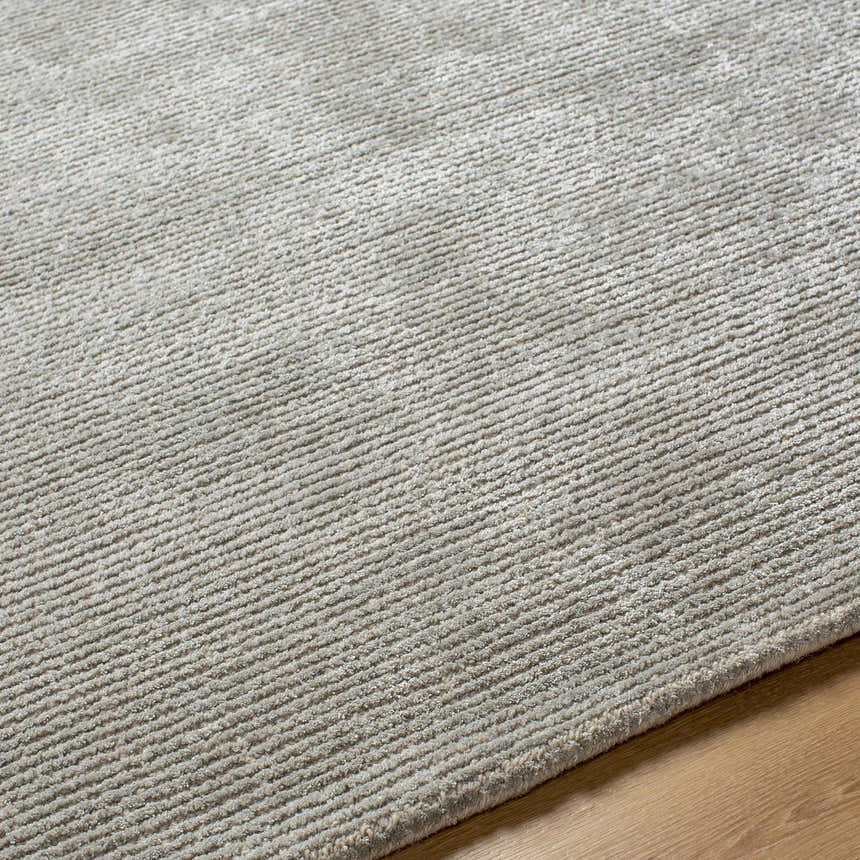 Close-up of the hand-tufted Makya Area Rug. Silver gray rug with subtle linear texture and soft pile. Texture