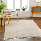 Bright living room with a Hosea Cream Area Rug, chair, and wood accents. Neutral tones create a calming, contemporary space. Roomscene-Rectangle