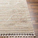 Close-up of the Inaya Area Rug. Beige and brown polyester rug with a contemporary design and decorative tassels. Front