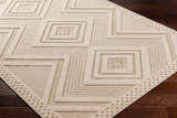 Close-up of the Aimee Lambswool Area Rug showing its geometric square pattern and textured, machine-woven construction. Corner