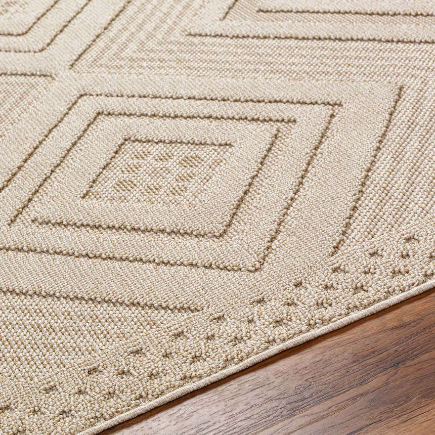 Close-up of the Aimee Lambswool Area Rug showing its geometric diamond pattern and soft, textured weave in camel and light brown. Texture