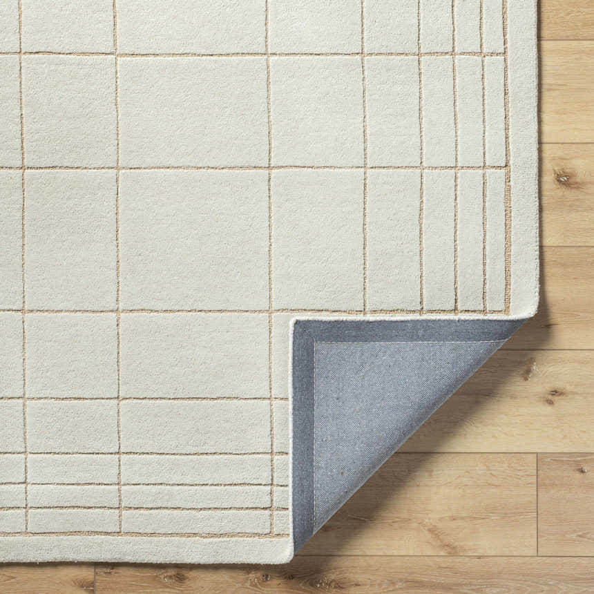 Close-up of the Sedna Wool Area Rug showing its medium gray and tan grid pattern and hand-tufted texture. Fold