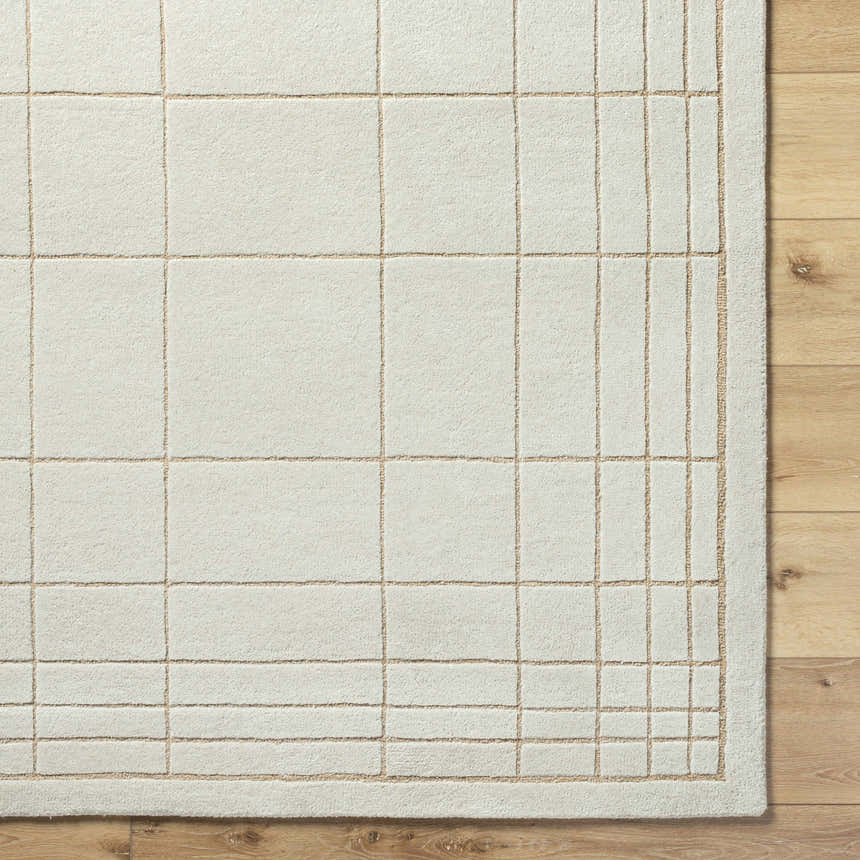 Close-up of the Sedna Wool Area Rug. Medium gray wool with a tan grid pattern on light wood flooring. Corner