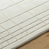 Close up of the Sedna Wool Area Rug showing its medium gray and tan geometric pattern. Texture