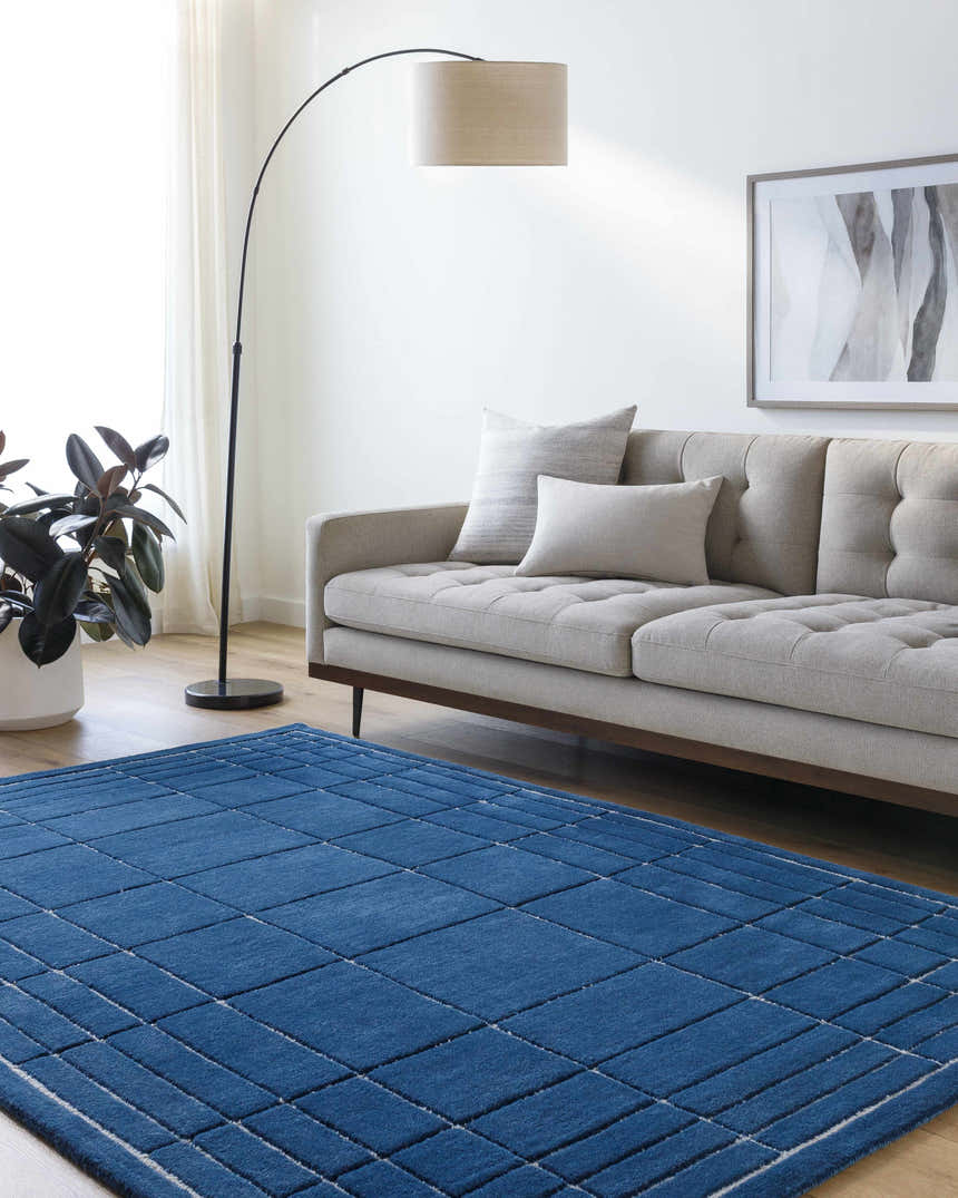 Living room scene with a gray sofa and the Sedna Navy Wool Area Rug on a wood floor. Roomscene-Rectangle