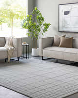 Contemporary living room with gray sofas and a Sedna Gray Wool Area Rug featuring a geometric grid pattern. Roomscene-Rectangle